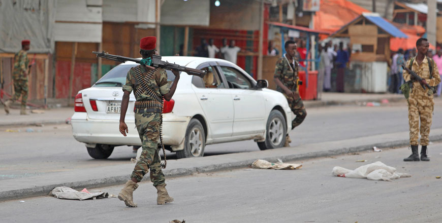 Somali government soldiers walk near a car after two armed militants were killed by Somali forces, at the Benadir checkpoint in Mogadishu, Somalia, on Sunday (Reuters photo)
