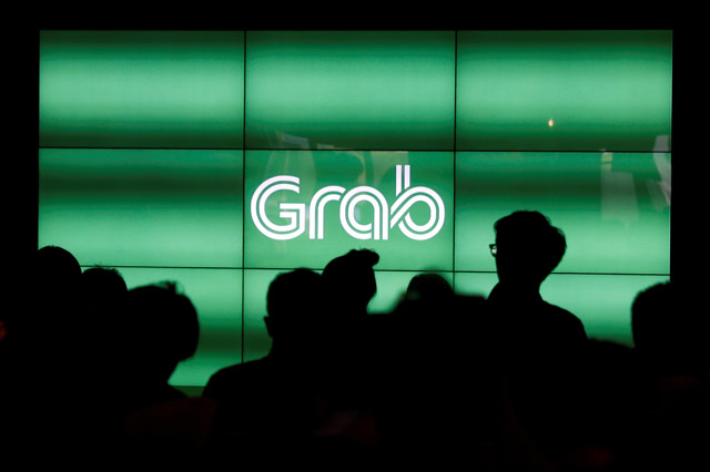 People wait for the start of ride-hailing company Grab's fifth anniversary news conference in Singapore on June 6 (Reuters file photo)