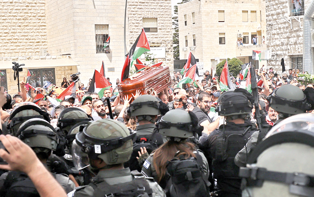 Israeli occupation forces attack Palestinian mourners carrying the coffin of slain Al Jazeera journalist Shireen Abu Akleh out of a hospital, before being transported to a church and then her resting place, in Jerusalem, on Friday (AFP photo)