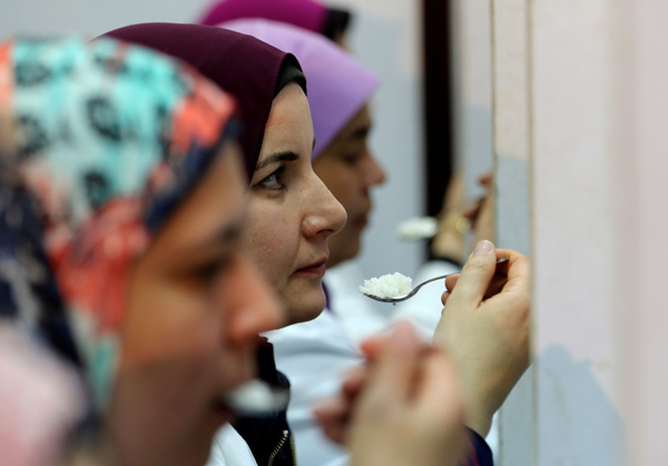 Food scientists taste samples of rice to make sure they fit Egyptian standards, in a research centre affiliated with Egypt's agriculture ministry in Cairo, Egypt, on March 25  (Reuters photo)