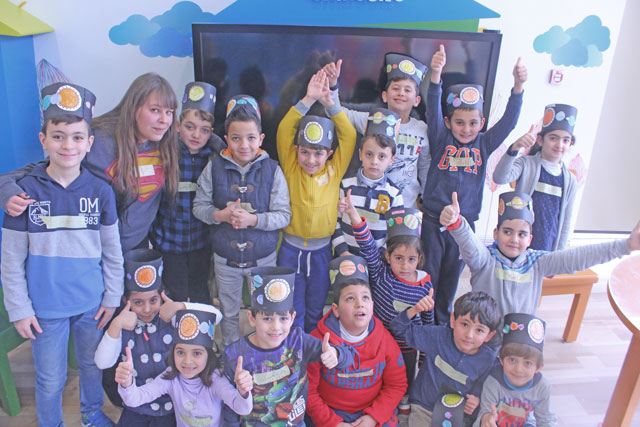 Co-founder of the Science League Farah Abu Hamdan poses for a group photo with children after a workshop (Photo courtesy of the Science League)