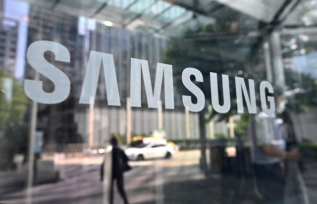 People walk past the Samsung logo displayed on a glass door at the company's Seocho building in Seoul, on Thursday (AFP photo)
