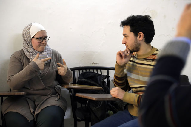 Syrian biomedical engineer and sign language teacher Wisal Al Ahdab communicates using sign language with 21-year-old deaf student Riyad Hommos during a class at the EEMAA association, an NGO centre for the deaf in Damascus’ Midan district, on Tuesday (AFP photo)