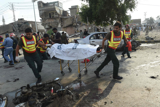 Pakistani rescue workers move the body of a victim at the site of an explosion in Lahore, on Monday (AFP photo)