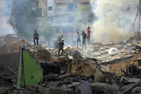 A firefighter (C) sprays water on the rubbles of a building at the site of an Israeli strike in southern Beirut on March 28, 2025 (AFP photo)