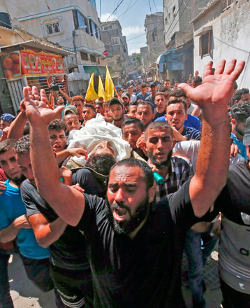 Palestinian mourners carry the body of Ahmed Omar, who was killed during a protest near the Israeli Erez crossing with the Gaza Strip, during his funeral in Al Shati Refugee Camp in Gaza, on Wednesday (AFP photo)