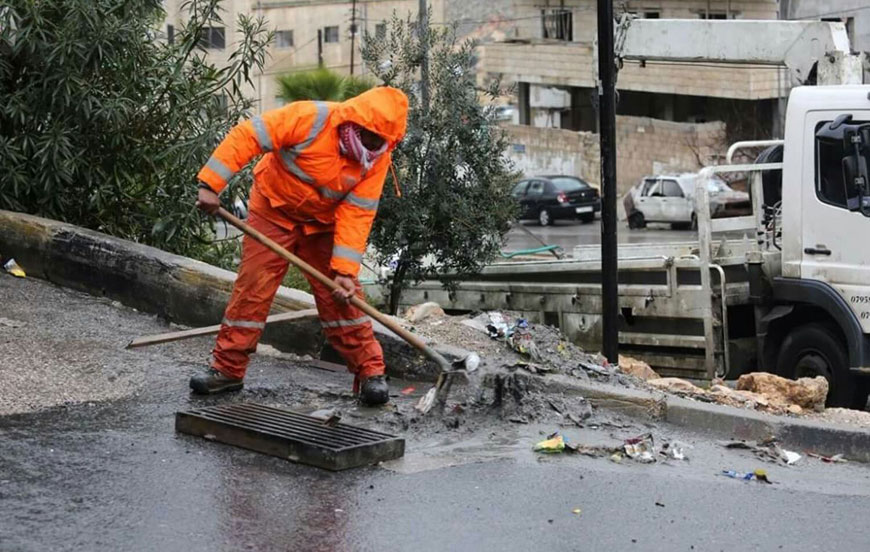A sanitation worker clears a blocked manhole in Amman on Friday (Photo courtesy of Greater Amman Municipality)