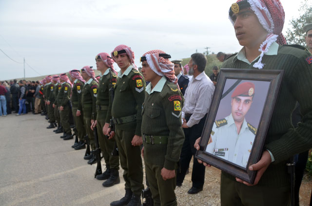 An army officer holds a photo of the late Major Rashed Zyoud during his funeral in Zarqa's Hashemiyeh District, on Wednesday (Photo by Muath Freij)