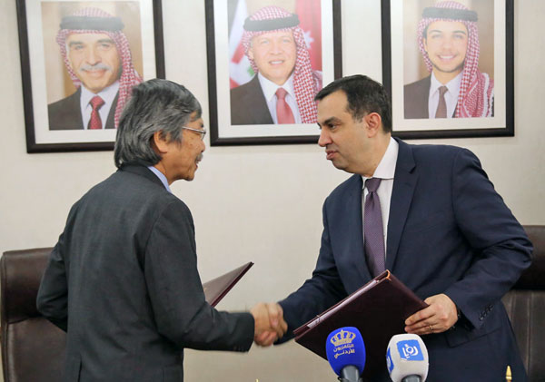 Minister of Planning and International Cooperation Imad Fakhoury and Japanese Ambassador to Jordan Shuichi Sakurai shake hands after signing an agreement in Amman, on Tuesday(Photo courtesy of Ministry of Planning and International Cooperation)