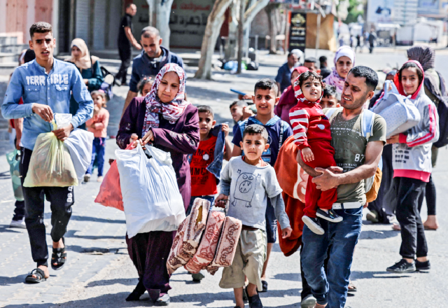 Palestinians carry some of their belongings in Beit Hanun in the northern Gaza Strip, as they flee Israeli air and artillery strikes, to a safer location, on Friday (AFP photo)