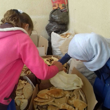 Students sort through collected bread to sell to fodder traders recently (Photo courtesy of Bread for Education)