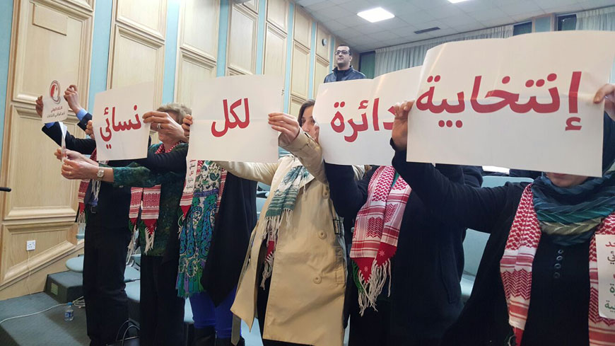 Women’s rights activists hold placards calling for a seat for women in each electoral district under the draft elections law during a Lower House session on Monday (Photo by Rana Husseini)
