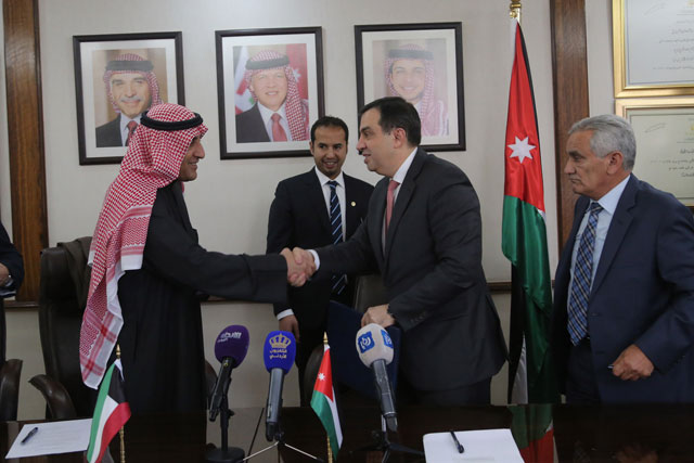 Planning and International Cooperation Minister Imad Fakhoury shakes hands with Kuwaiti Fund for Arab Economic Development Director General Abdulwahab Ahmad Al Bader in Amman, on Sunday (Photo courtesy of Ministry of Planning and International Cooperation)
