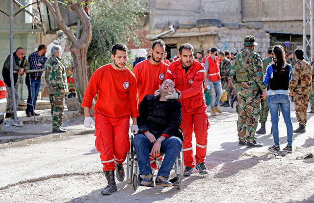 Members of the Syrian Red Crescent push an evacuated injured man into the government side of the Wafideen checkpoint on the outskirts of the Syrian capital Damascus, neighbouring the Eastern Ghouta enclave, on Wednesday (AFP photo)