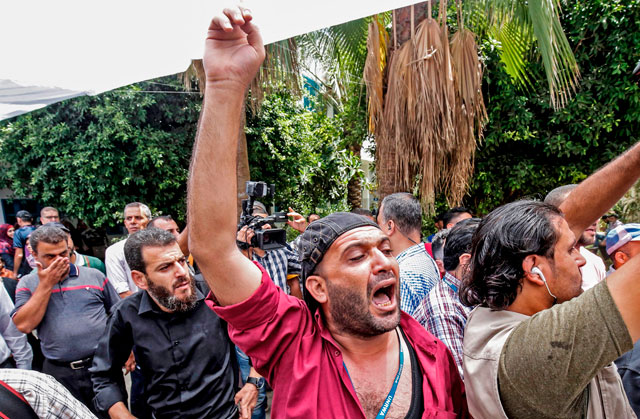 Palestinian employees of the UN agency for Palestinian refugees, UNRWA, take part in protest against job cuts, at its headquarters in Gaza City on Wednesday (AFP photo)
