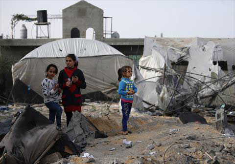 Palestinian children gather near agricultural nurseries damaged by an Israeli air strike earlier this week in Rafah, in the southern Gaza Strip on Wednesday (AFP photo)