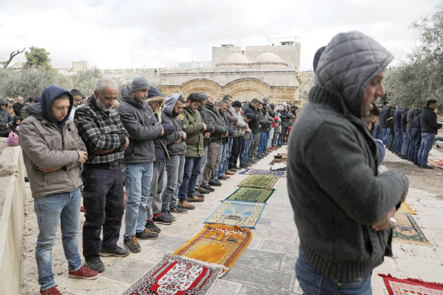 Palestinian Muslims attend Friday prayers outside the Bab Al Rahma in Al Aqsa Mosque complex in Jerusalem's Old City on Friday (Reuters photo)