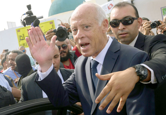 Tunisia's presidential candidate Kais Saied waves to supporters as he leaves a polling station in the capital Tunis on Sunday during the second round of the presidential election (AFP photo)