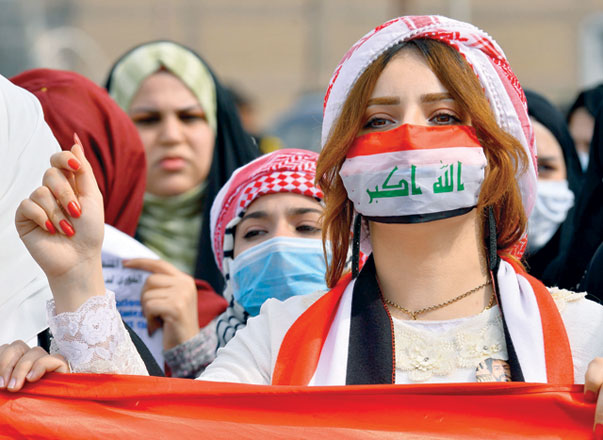 Anti-government protesters demonstrate wearing surgical masks in the central Iraqi shiite holy shrine city of Najaf on Monday (AFP photo)
