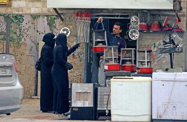 Women buy a kerosene heater from a shop in downtown Amman last winter (Photo by Amjad Ghsoun)