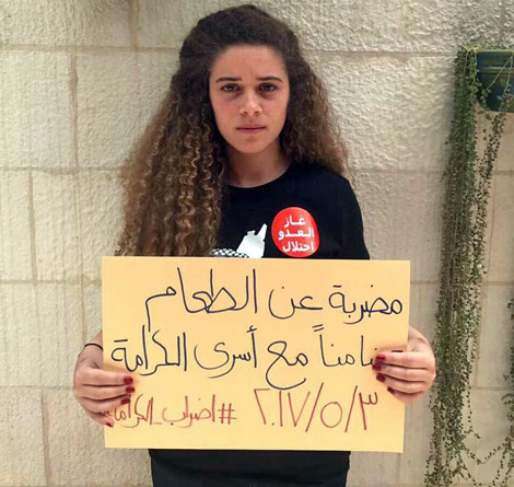 A Boycott, Divestment and Sanctions activist poses with a sign in Arabic reading ‘Hunger striking in solidarity with the prisoners of dignity [karameh]. 03/05/2017 #Dignity_Strike’ (Photo by Suzanna Goussous)