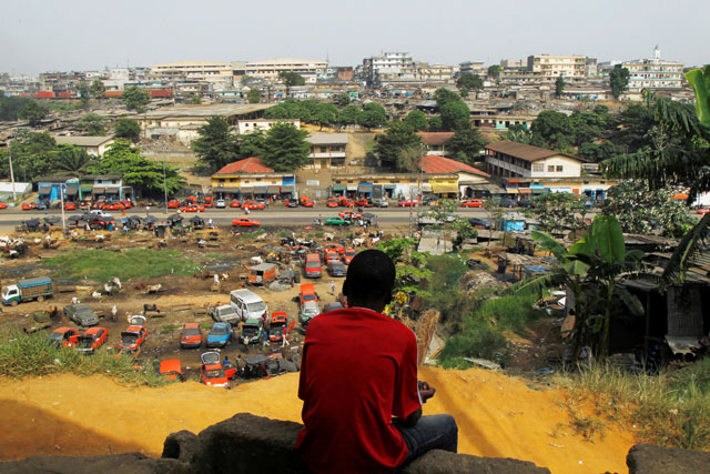 A boy sits on a hill overlooking the village of Attiekoube in Abidjan, Ivory Coast, on Thursday  (Reuters photo)