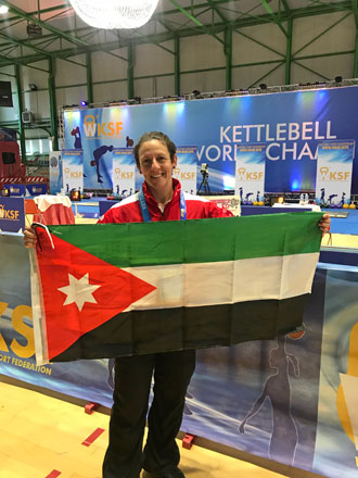 Mona Bitar poses with the Jordanian flag at the 2018 Kettlebell World Championship in Milan recently (Photo courtesy of Mona Bitar)