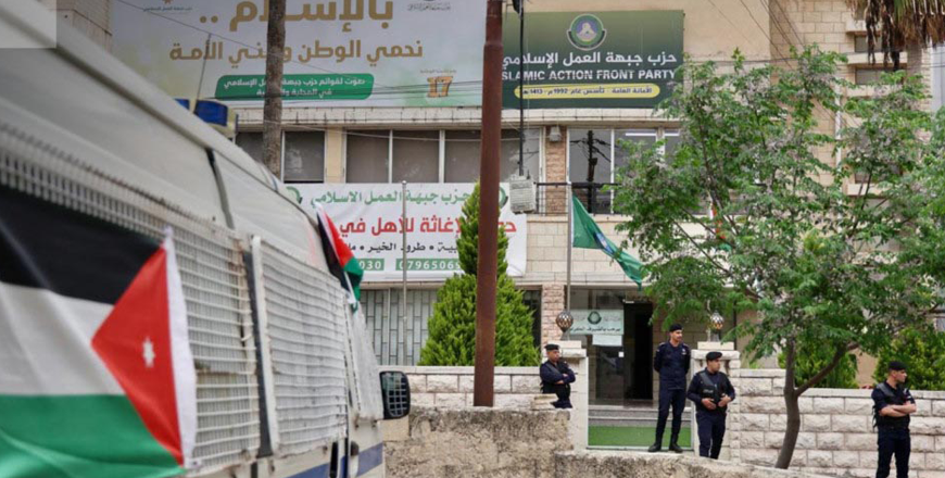   Security personnel stand in front of the headquarters of the Islamic Action Front party in Amman on Wednesday (Al Mamlakah TV photo)