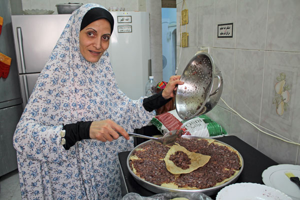 Nadia prepares musakhan at her Amman home recently (Photo courtesy of WFP/Lara Darwazah)