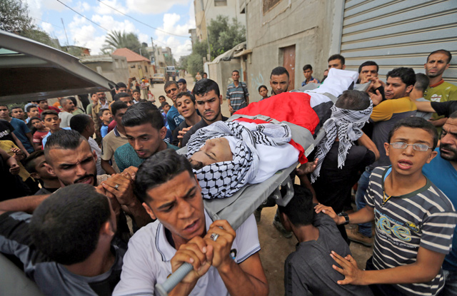 Mourners carry the body of 17-year-old Palestinian boy Belal Khafaja, who was killed by Israeli forces during a protest at the Israel-Gaza border, during his funeral in Rafah in the southern Gaza Strip, on Saturday (Reuters photo)