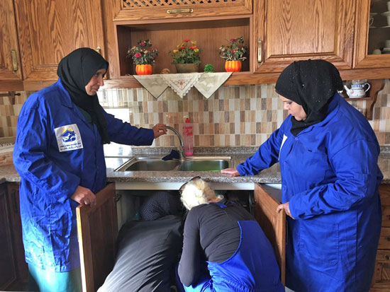 Women plumbers work on a kitchen sink at a house in Madaba, some 30km southwest of Amman, recently  (Photo by Muath Freij)