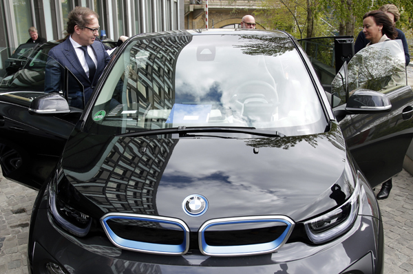 German Transportation Minister Alexander Dobrindt (left) and his staff members get on the minister's electric car after a press conference in Berlin, Germany, Wednesday (AP photo)