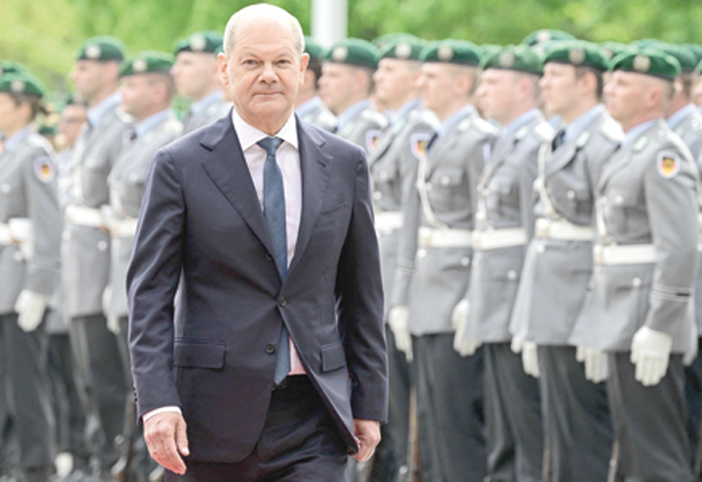 German Chancellor Olaf Scholz walks past the honour guard after saluting them before the arrival of Ukraine's president on Sunday at the Chancellery in Berlin (AFP photo)