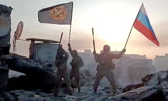 This video grab taken from a handout footage posted on Saturday on the Telegram account of the press service of Concord — a company linked to the chief of Russian mercenary group Wagner, Yevgeny Prigozhin — shows members of Wagner group waving a Russian national flag and Wagner Group's flag on the rooftop of a damaged building in Bakhmut (AFP photo)