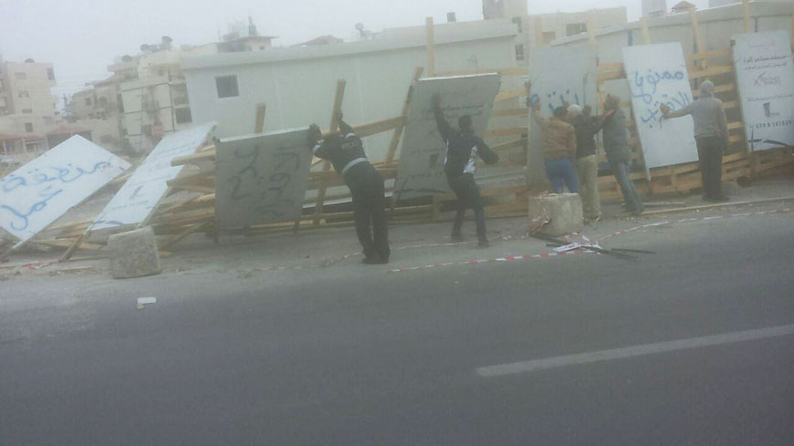 Police officers and residents remove wood and steel planks that fell at a construction site in Amman on Tuesday due to strong winds (Photo courtesy of Amen FM)
