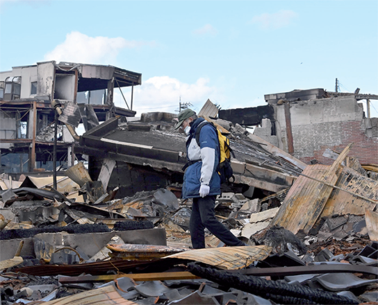 A man searches for goods on the ruins of his burnt house in the city of Wajima, Ishikawa prefecture on Thursday (AFP photo)