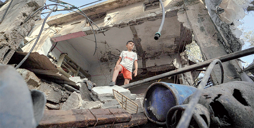 A Palestinian boy stands on the rubble of a destroyed house in Nuseirat following Israeli bombardment overnight on May 23, 2024 (AFP photo)
