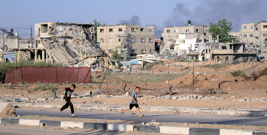 Palestinian boys run as smoke billows during Israeli bombardment east of Al Bureij refugee camp in the central Gaza Strip on Wednesday (AFP photo)
