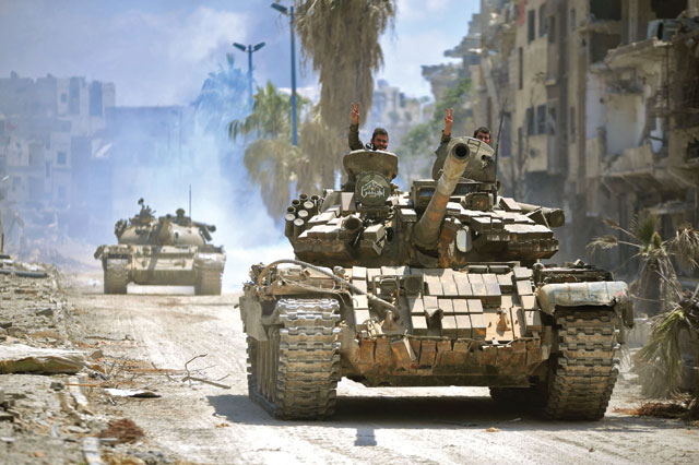 This handout photo released by the official Syrian Arab News Agency on Sunday shows government forces heading towards militant positions in the Hajar Al Aswad district on the southern outskirts of Damascus (AFP photo)