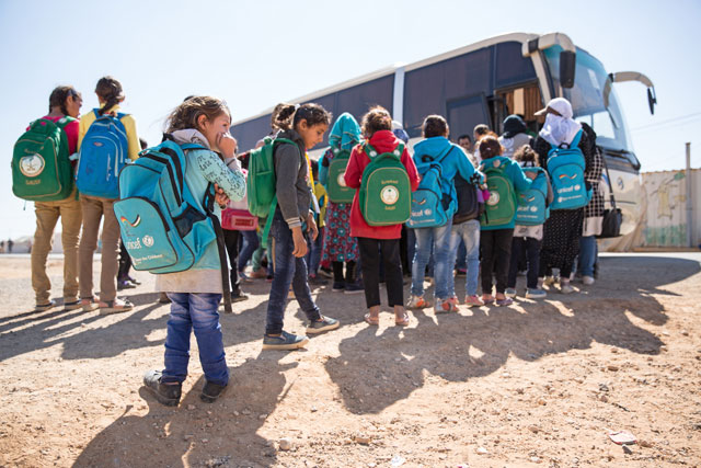 Children enter the IOM bus to go to school and back in Azraq refugee camp recently  (Photo courtesy of Amanda Nero / IOM)