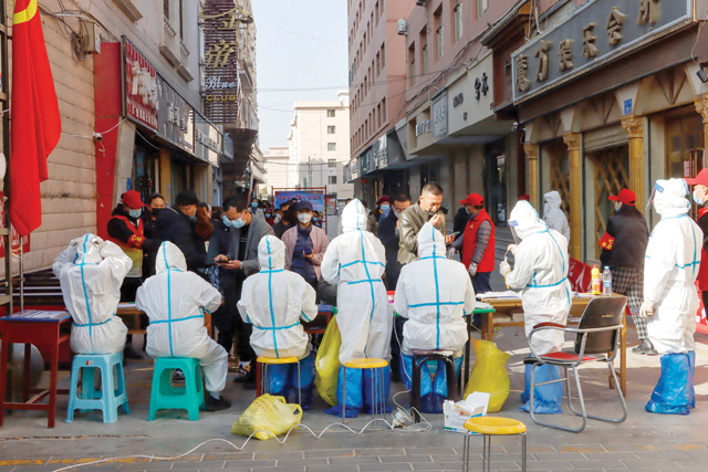 This photo taken on Saturday shows medical staff members conducting nucleic acid tests for the COVID-19 coronavirus in Zhangye in China's north-western Gansu province (AFP photo)