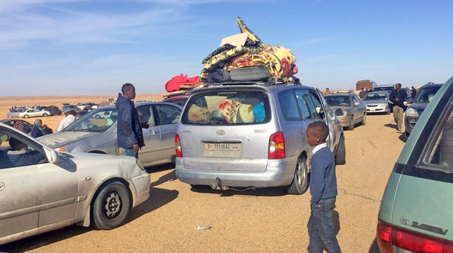 Displaced Libyans from the western city of Tawergha wait by their cars to enter the city, which lies about 250 kilometres east of the capital Tripoli, on Thursday, as armed groups from nearby Misrata set up roadblocks to prevent the return of hundreds of families from the town that supported Libyan leader Muammar Qadhafi in the country's 2011 revolution (AFP photo)