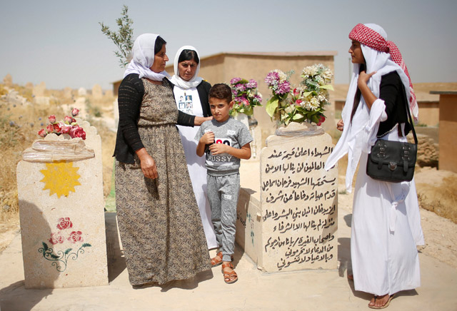 Yazidis visit a cemetery during a commemoration to mark three years since Daesh launched what the United Nations said was a genocidal campaign against them in Sinjar region, Iraq, on Thursday (Reuters photo)