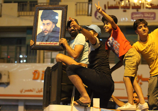 An Iraqi man celebrates with a photo of Shiite cleric Mouqtada Sadr during the general election in Baghdad on Monday (AFP photo)