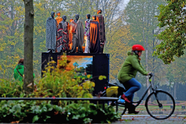 A cyclist passes a sculpture featuring climate refugees created by Danish artist Jens Galschiot at Rheinaue Park during the COP23 United Nations Climate Change Conference in Bonn, Germany (AFP photo)