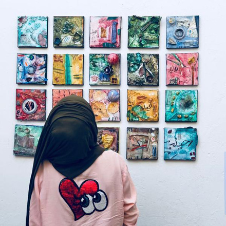 A visitor of the exhibition looks at the work of the young refugee girls recently  (Photo courtesy of The Orenda Tribe)