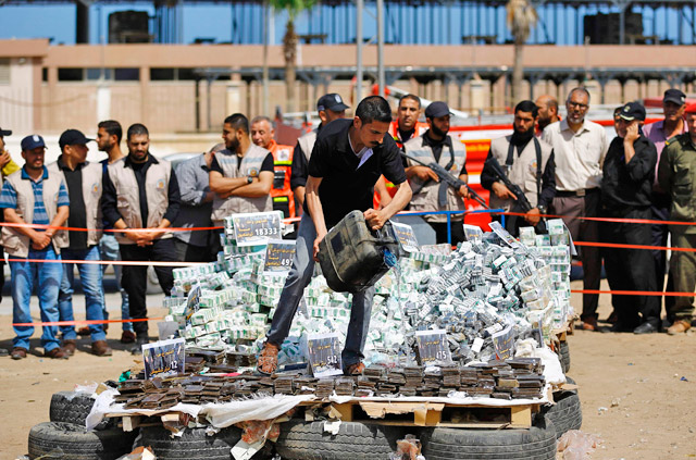 A member of the Hamas security forces sets fire to a pile of confiscated bars of hashish and analgesic pills, seized since the beginning of the year in Gaza City, on May 11 (AFP photo)