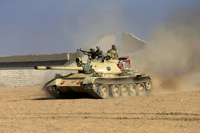 Members of the Iraqi Army ride in a tank during clashes with the Daesh terror group militants, south of Mosul, Iraq, on Saturday (Reuters photo)