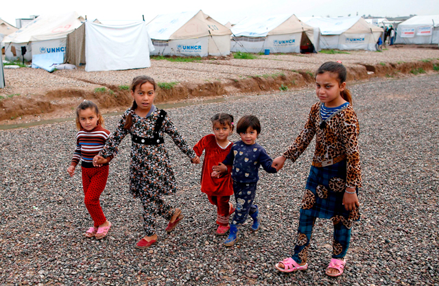 Displaced Iraqi children, who fled Mosul, walk at the Hasan Sham Camp, 30 kilometres east of Mosul, on Friday (AFP photo)