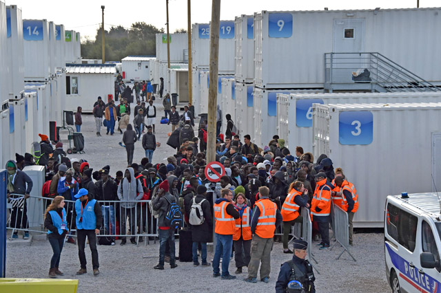 This file photo taken on November 2, 2016, shows members of La Vie Active association (right) and the UNHCR (left) standing near unaccompanied migrant minors from the demolished ‘Jungle’ migrant camp in Calais, waiting to board a bus to be transferred to reception centres around France, in Calais, northern France (AFP photo)